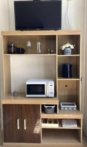 モンテビデオにあるHabitacion Equipadaの電子レンジ(棚の上にテレビ付)