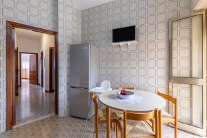 a kitchen with a table and chairs and a refrigerator at Casa Iblea in Melilli
