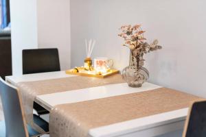 a dining room table with a vase with flowers in it at Bolero2 apartman in Budapest