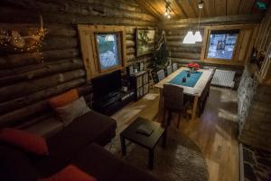 a living room with a couch and a table in a log cabin at Villa Kivikoski in Pyhtaa