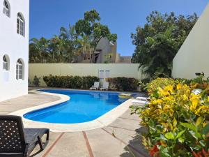 a swimming pool in the middle of a yard at Costambar Ocean Breeze - Beachfront Apartment with Pool in San Felipe de Puerto Plata +8 photos