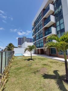 un patio con palmeras frente a un edificio en Rio Park Av, Sea View One - by TRH Home Stay, en Recife