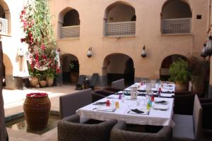 Riad El Koudia في Douar el Koudia: غرفة طعام مع طاولات وكراسي ومبنى
