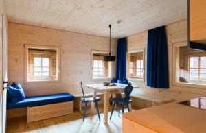 a dining room with a table and blue chairs at Alfenalm - Ferienwohnungen am Berg - Giatla Haus in Innervillgraten