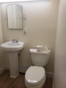 a bathroom with a toilet and a sink and a mirror at Town & Country Inn in Seekonk