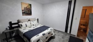 a bedroom with a bed and a painting on the wall at The Big 5 - Leopard in Randburg