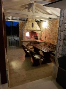 a stone patio with a bench and a fireplace at Apartments Sun Dance 2 with heated Pool in Novalja