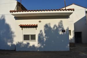 a white building with a window and a shadow at Ioannis Home at Skonizo in Chania