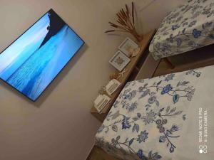 a bedroom with a tv hanging on the wall at Kurt e famiglia in Casalzuigno