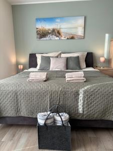 a bedroom with a large bed with two pairs of shoes at Kleine Auszeit -- inklusive Parkplatz & WiFi, Geschirrspüler, Waschmaschine & Terrasse mit Strandkorb -- Perfekt für Urlaub & Business in Scharbeutz