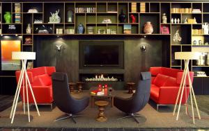 a living room with red furniture and a fireplace at citizenM Southwark Bankside in London
