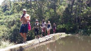 圣约翰港Jungle Monkey Backpackers的一群人穿过一座河上的桥梁