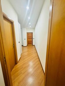 an empty hallway with a door and a wooden floor at Garden Palace House Messina in Messina
