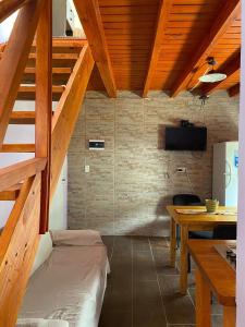 Una habitación con una cama y una mesa y escaleras. en Cabaña Familia de Campo 3, en El Chaltén