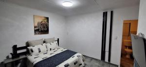 a bedroom with a bed in a white room at The Big 5 - Leopard in Randburg +3 photos