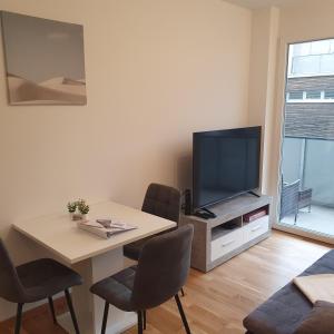 a living room with a table and a television at Primelweg Apartments in Graz