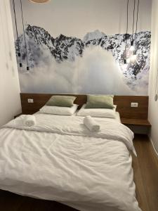 un letto con due asciugamani sopra in una camera da letto di Apartmani Snowflake a Jahorina