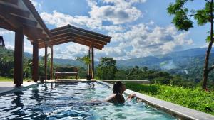 a woman in a swimming pool with mountains in the background at Fundo Shanti in Lamas