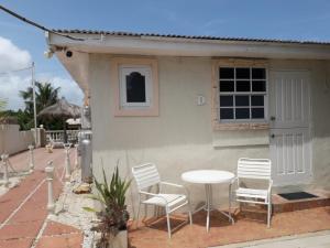 a table and chairs in front of a house at Maria Mulata Apartments in Noord