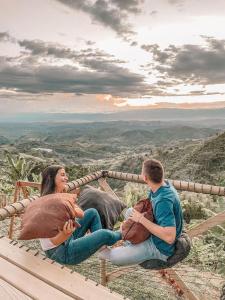 ManzanilloGlamping Aire Sevilla Valle的坐在山顶上的男人和女人