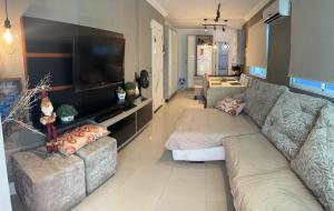 a living room with two couches and a flat screen tv at Apartamento para alugar na temporada a 150m do mar in Itapema