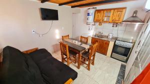 a living room with a couch and a table in a kitchen at Estadía temporal in Quebrada de los Códores