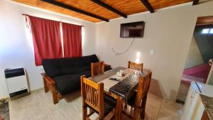 a living room with a dining room table and a couch at Estadía temporal in Quebrada de los Códores