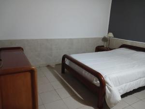 a bedroom with a bed with a white sheets and a table at Mardifiore 1 ORO in General Madariaga