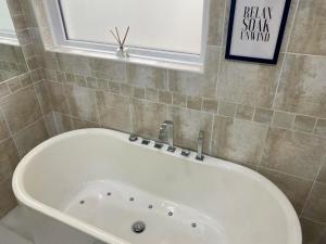 a white bath tub in a bathroom with a window at Seaview Cottage on the Island in Millbay +74 photos