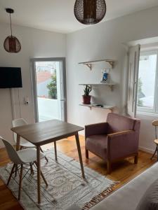 a living room with a wooden table and a chair at Casa dos Mouros in Évora