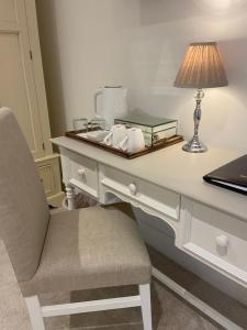 a white desk with a lamp and a laptop on it at Abbey Green Farm in Wem