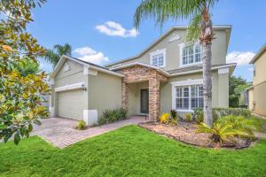 a house with a palm tree in a yard at Completely Remodeled 5 Bedroom Disney Pool Home in Davenport