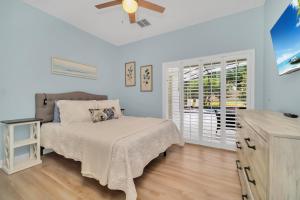 a bedroom with a bed and a ceiling fan at Completely Remodeled 5 Bedroom Disney Pool Home in Davenport