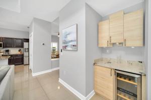 a kitchen with white walls and wooden cabinets at Completely Remodeled 5 Bedroom Disney Pool Home in Davenport +42 photos