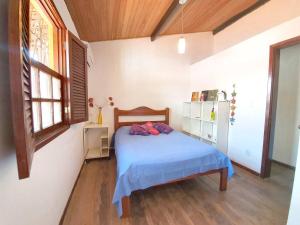 a bedroom with a bed with blue sheets and a window at Casa Guio in Salvador