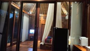 a room with sliding glass doors and a tv at Baruna Sari Villa yoga and reatret view jungle in Ubud