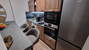 a kitchen with a stainless steel refrigerator and wooden cabinets at Rebeka Luxury Apartment in Tryavna
