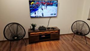 a living room with two chairs and a flat screen tv at Rebeka Luxury Apartment in Tryavna