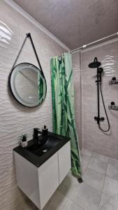 a bathroom with a sink and a shower with a mirror at Rebeka Luxury Apartment in Tryavna