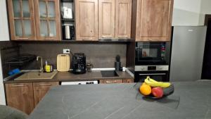 a kitchen with a bowl of fruit on a counter at Rebeka Luxury Apartment in Tryavna