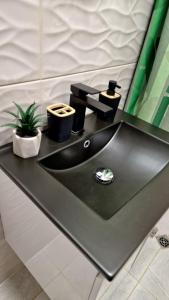 a black bathroom sink with a faucet at Rebeka Luxury Apartment in Tryavna