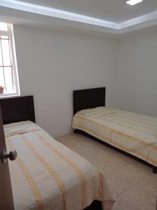 a bedroom with two beds in a room at APARTAMENTo CUMBRES ANDINAS 3 Hab 5 personas in San Cristóbal