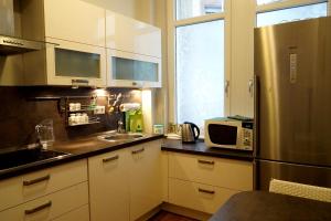 cocina con armarios blancos y nevera de acero inoxidable en Vip Apartment an den Thermen, en Baden-Baden