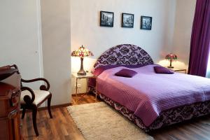 1 dormitorio con 1 cama púrpura con 2 lámparas y 1 silla en Vip Apartment an den Thermen, en Baden-Baden