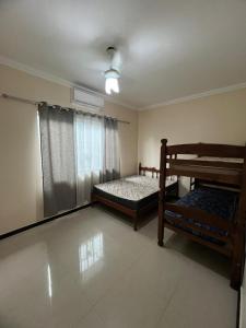 a room with two beds and a window at Casa grande pé na areia Peruibe in Peruíbe