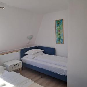 a bedroom with two beds and a picture on the wall at Piccola Italia Casa Racovita in Cluj-Napoca