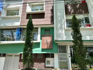 een gebouw met bomen ervoor bij Laureles Guest House LGH Hotel in Medellín