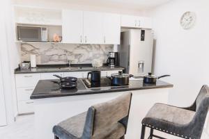a kitchen with two chairs and a counter with two pots on the stove at Excepcional One bedroom Suite in Cabo San Lucas
