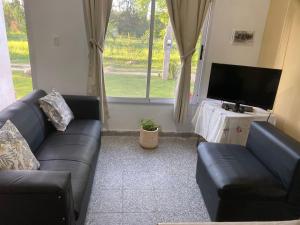 a living room with a couch and a tv at Casa en La Puntilla in Belén