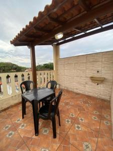 a black table and chairs on a patio at Suítes Cosfer in Saquarema +4 photos